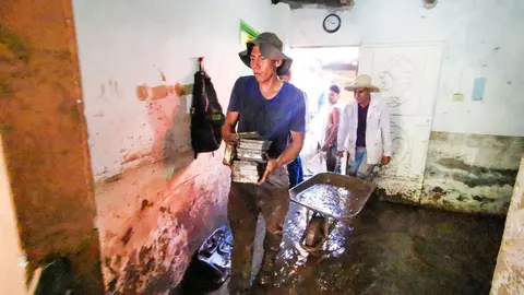 Los voluntarios utilizaron todo lo que estaba en sus manos para sacar el lodo de las casas. Foto de El Salvador Times.