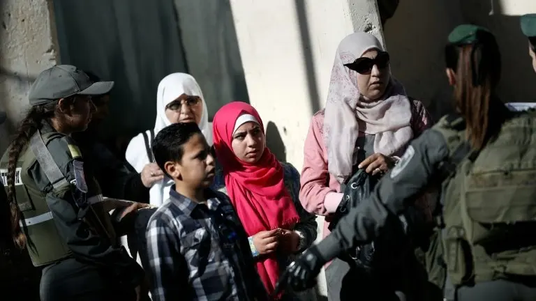 <p>Una familia palestina trata de cruzar por el punto de control militar israelí entre la ciudad cisjordana de Belén y Jerusalén este viernes 10 de junio</p>