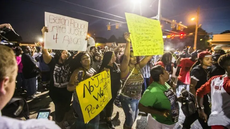 <p>Un grupo de manifestantes protesta por la muerte de Alton Sterling a manos de un policía el 6 de julio de 2016 en Baton Rouge, Luisiana</p>
