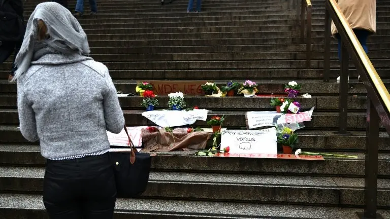 <p>Una mujer observando las flores y mensajes dejados ante la catedral de Colonia, el 11 de enero de 2016, a raíz de las agresiones sexuales denunciadas en la noche de fin de año, que conmocionaron a la sociedad alemana</p>