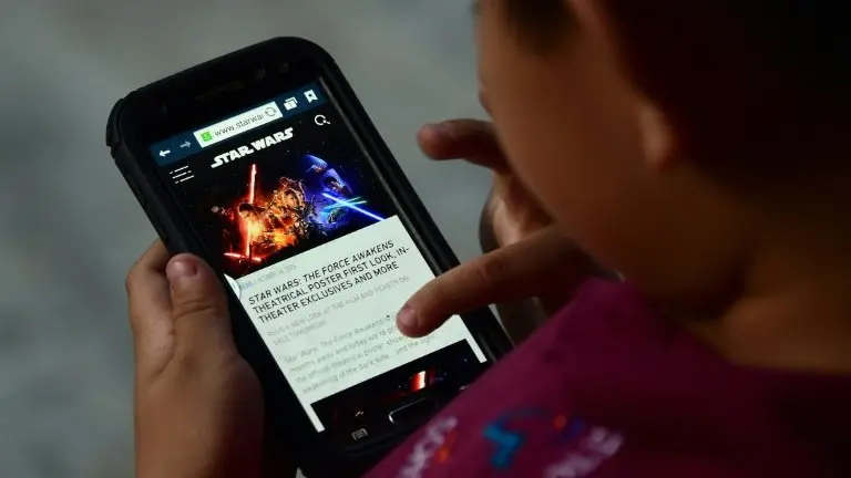 Un niño lee un artículo sobre la última película de la saga Star Wars en un teléfono móvil el 20 de octubre de 2015 en Los Ángeles, Estados Unidos