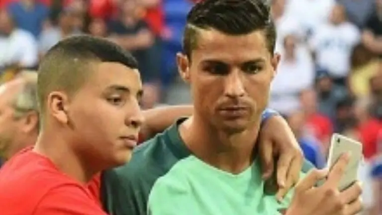 <p>El portugués Cristiano Ronaldo (D) se toma una foto junto a un aficionado durante la semifinal de la Eurocopa ante Gales, el 6 de julio de 2016, en Décines-Charpieu, Francia</p>