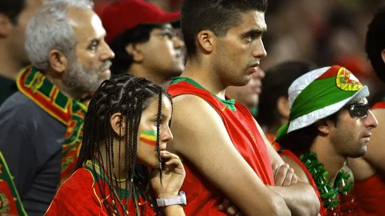 <p>Unos aficionados portugueses miran, apesadumbrados, la final de la Eurocopa 2004 entre Portugal y Grecia el 4 de julio de ese año en el Estadio de la Luz, Lisboa</p>