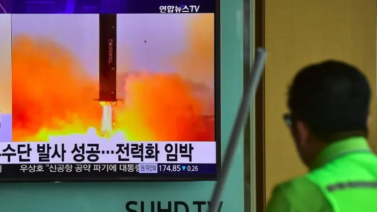 <p>Un hombre pasa por delante de una pantalla de televisión durante la emisión de información sobre un ensayo de misil norcoreano Musudan el 23 de junio de 2016 en una estación de tren en Seúl</p>