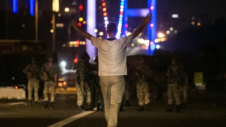 <p>Un hombre se enfrenta a las fuerzas militares turcas en el puente sobre el Bósforo, en Estambul, en medio de manifestaciones contra el anuncio de un golpe de Estado en Turquía, el 15 de julio de 2016</p>