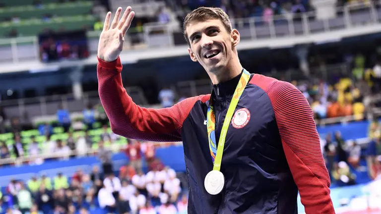 Silver medallist USA's Michael Phelps waves during the medal ceremony of the Men's 100m Butterfly Final during the swimming event at the Rio 2016 Olympic Games at the Olympic Aquatics Stadium in Rio de Janeiro on August 12, 2016.   / AFP PHOTO / CHRISTOPHE SIMON