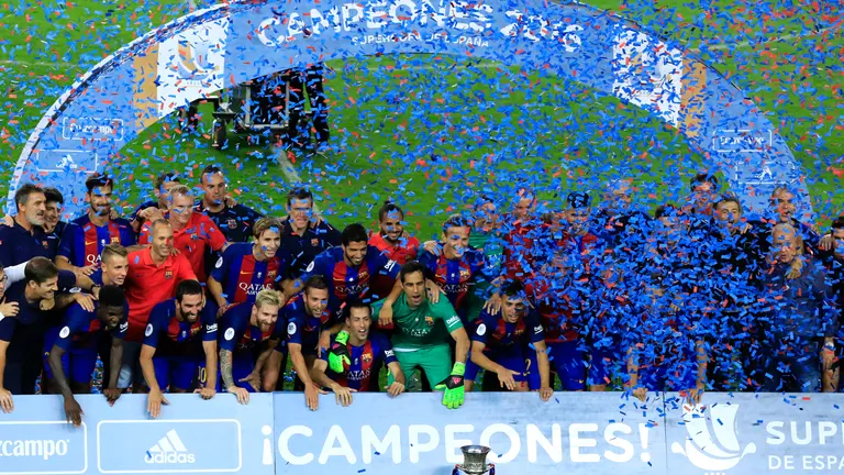 FC Barcelona celebrate with the trophy after winning the second leg of the Spanish Supercup football match between FC Barcelona and Sevilla FC at the Camp Nou stadium in Barcelona on August 17, 2016. / AFP PHOTO / PAU BARRENA