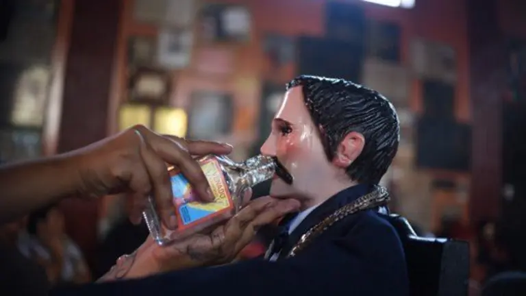A woman prays at the Temple of San Simon in the municipality of San Andres Iztapa in Chimaltenango, some 40 km west of Guatemala City, on October 28, 2016, during a pagan festival to honor the saint. 
Thousands of devotees bring cigarettes and spirits offerings to the saint --not recognized by the Catholic Church-- who is believed to be the protector of the homeless, prostitutes, alcoholics and drug-traffickers. / AFP PHOTO / JOHAN ORDONEZ