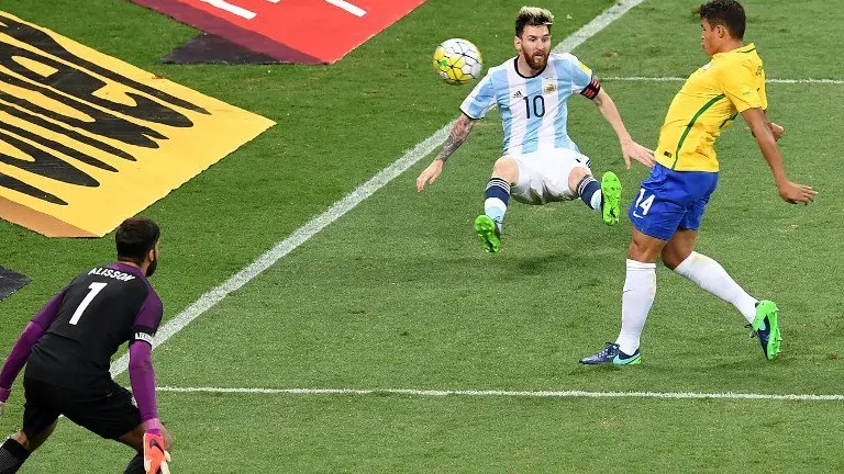 Argentina's Lionel Messi (C) is marked by Brazil's Thiago Silva (R) during their 2018 FIFA World Cup qualifier football match in Belo Horizonte, Brazil, on November 10, 2016. / AFP PHOTO / EVARISTO SA