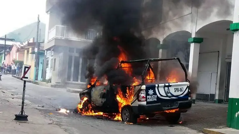 A police car burns in flames at Catemaco community in Veracruz, Mexico on November 12, 2016, during a protest after priest Jose Luis Sanchez disappeared. 
Furious residents of Catemaco municipality sacked the city hall and burnt a police car as they protested for second consecutive day for the disappearance of a priest, who was allegedly kidnapped.  / AFP PHOTO / EDUARDO MURILLO
