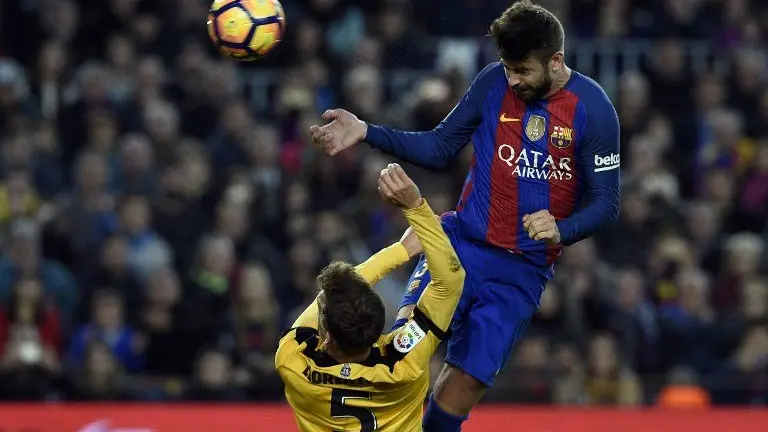 Barcelona's defender Gerard Pique (R) heads the ball past Malaga's midfielder Mikel during the Spanish league football match FC Barcelona vs Malaga CF at the Camp Nou stadium in Barcelona, on November 19, 2016. / AFP PHOTO / LLUIS GENE