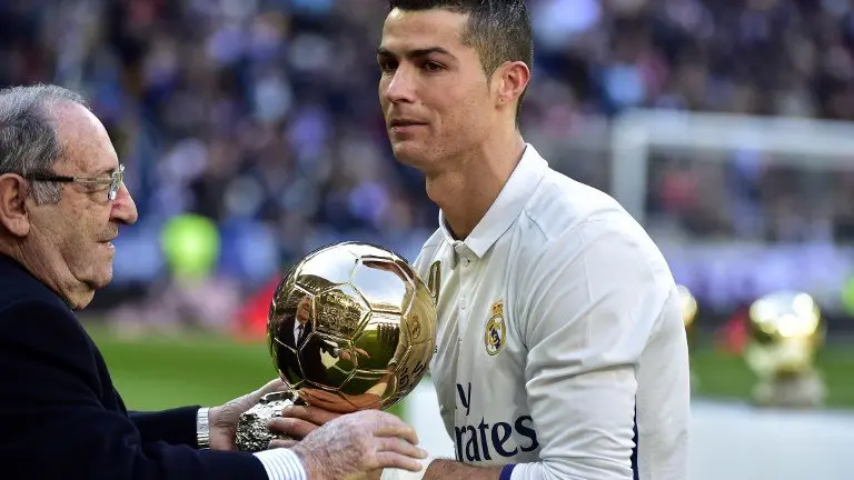 Former Real Madrid's Spanish player Francisco "Paco" Gento (L) handovers the Ballon d'Or at Real Madrid's Portuguese forward Cristiano Ronaldo during the handover ceremony of Ronaldo's Ballon d'Or 2016 before the Spanish league football match Real Madrid CF vs Granada FC at the Santiago Bernabeu stadium in Madrid on January 7, 2017.
Real Madrid won 5-0. / AFP PHOTO / GERARD JULIEN