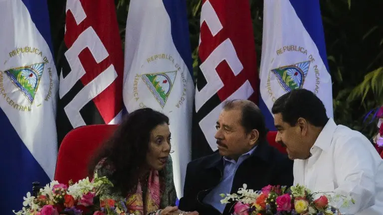 Nicaraguan President Daniel Ortega (C), Venezuelan President Nicolas Maduro (R) and Nicaraguan Vice-President Rosario Murillo talk during the inauguration ceremony for his fourth term in office in Managua on January 10, 2017. / AFP PHOTO / INTI OCON