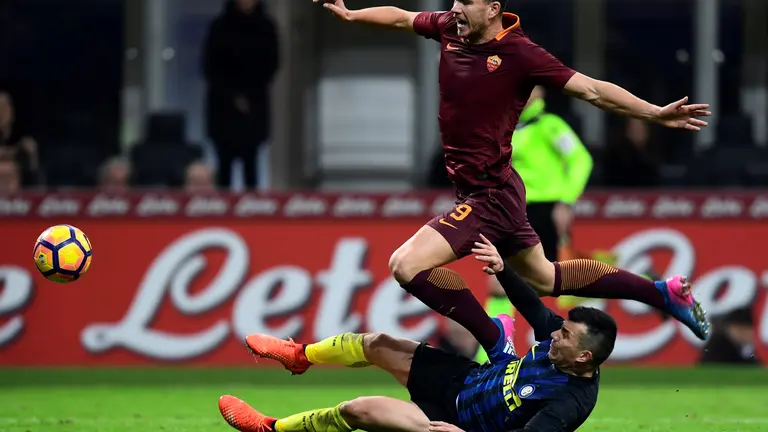 AS Roma's Bosnian forward Edin Dzeko (up) vies with Inter Milan's Chiliean midfielder Gary Medel during the Italian Serie A football match Inter Milan vs AS Roma at the San Siro stadium in Milan on February 26, 2017. / AFP PHOTO / MIGUEL MEDINA
