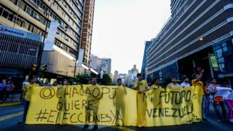 Venezuelan opposition activists, chanting slogans against the government of President Nicolas Maduro, march along a street of Caracas on March 31, 2017.
Venezuela's Supreme Court took over legislative powers Thursday from the opposition-majority National Assembly, whose speaker accused leftist President Nicolas Maduro of staging a "coup". / AFP PHOTO / FEDERICO PARRA