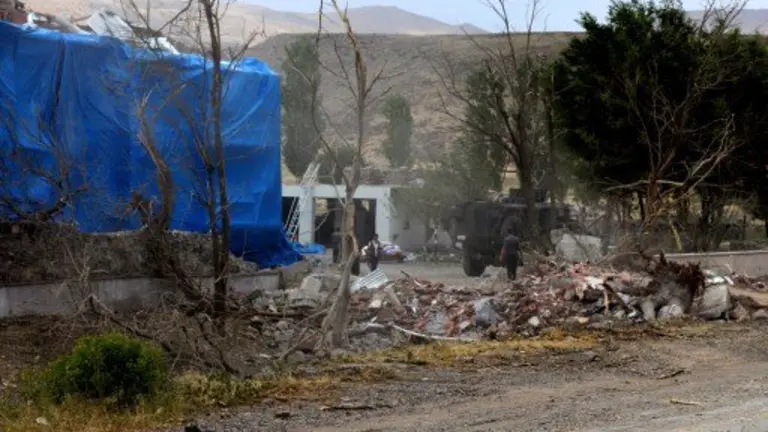 Wreckage lies on the ground in front of a Turkish millitary station covered by a tarpaulin after a suicide atack on August 2, 2015  in east Turkey town Dogubeyazit in Agri Province. Two Turkish soldiers were killed and 24 wounded in a suicide bombing blamed on militants of the outlawed Kurdistan Workers Party (PKK) on their local headquarters in eastern Turkey, reports said. AFP PHOTO /STRINGER / AFP PHOTO / STR