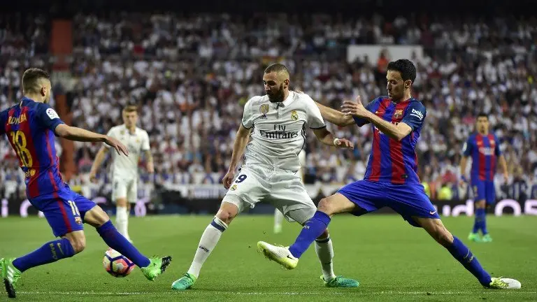 Karim Benzema y Sergio Busquets durante el clásico español