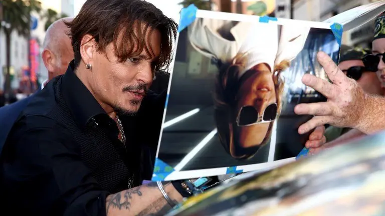HOLLYWOOD, CA - MAY 18: Actor Johnny Depp signs autographs for fans during the premiere of Disney's "Pirates Of The Caribbean: Dead Men Tell No Tales" at Dolby Theatre on May 18, 2017 in Hollywood, California.   Rich Fury/Getty Images/AFP