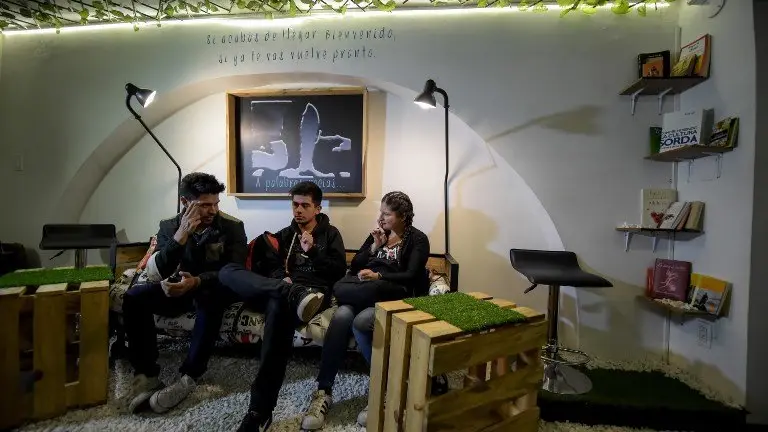 Deaf customers communicate through sign language at the "Sin Palabras" (Without Words) coffee bar in Bogota on July 19 , 2017
With menus with vignettes depicting sign language, lamps to call the waiter and the floor that vibrates according to the rhythm of music, the cafe  seeks to impose itself in the city as the first one of its kind for the deaf population. / AFP PHOTO / Raul Arboleda / TO GO WITH AFP STORY by Rodrigo ALMONACID