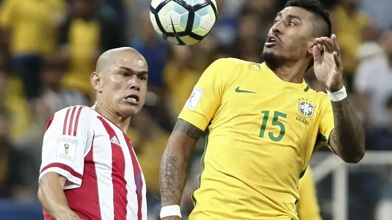 Brazil's midfieler Paulinho (R) and Paraguay's defender Dario Veron jump for the ball during their 2018 FIFA World Cup qualifier football match in Sao Paulo, Brazil on March 28, 2017. / AFP PHOTO / Miguel SCHINCARIOL