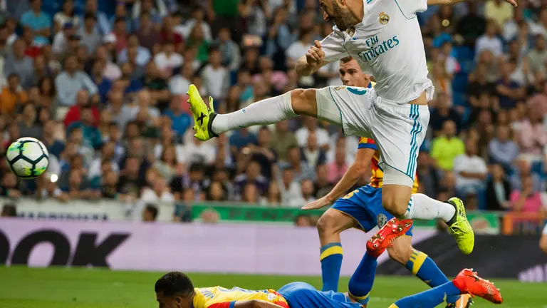 Real Madrid's French forward Karim Benzem (R) kicks the ball during the Spanish league football match Real Madrid CF vs Valencia CF at the Santiago Bernabeu stadium in Madrid on August 27, 2017. / AFP PHOTO / CURTO DE LA TORRE