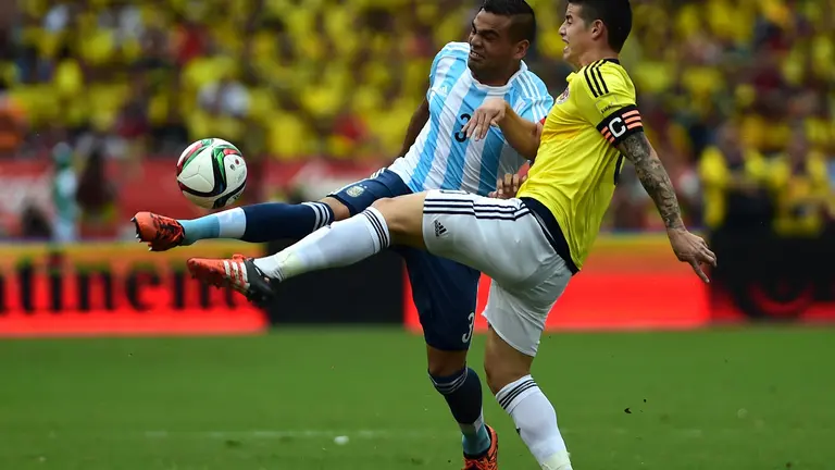 Argentina's Gabriel Mercado (L) and Colombia's James Rodriguez vie for the ball during their Russia 2018 FIFA World Cup South American Qualifiers football match, in Barranquilla on November 17, 2015.    AFP PHOTO / LUIS ROBAYO