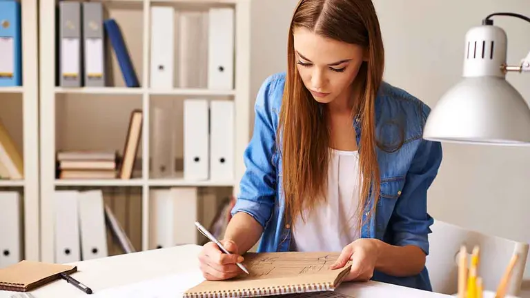 Portrait of pretty student making sketch at lesson