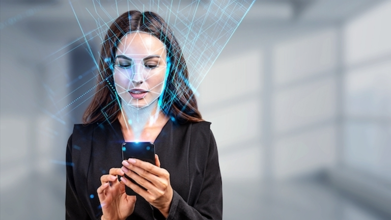 Businesswoman with phone in hands, biometric verification and face detection. Unlocking smartphone with facial scanner. Concept of face id and high tech technology
