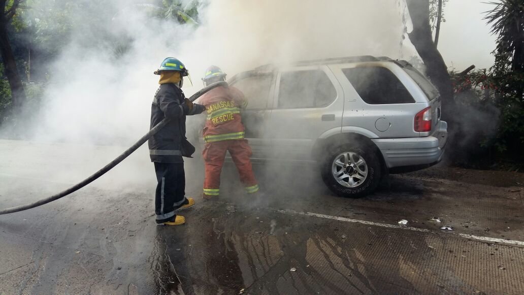 bomberos apagan llamas de carro incendiado