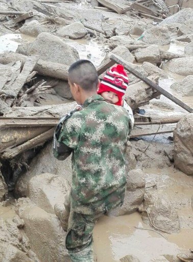 Handout picture released by the Colombian Army press office showing a soldier carrying a baby after mudslides caused by heavy rains, in Mocoa, Putumayo department, on April 1, 2017.
Mudslides in southern Colombia -caused by the rise of the Mocoa River and three tributaries- have claimed at least 16 lives and injured some 65 people following recent torrential rains, the authorities said.   / AFP PHOTO / EJERCITO DE COLOMBIA / HO / RESTRICTED TO EDITORIAL USE - MANDATORY CREDIT AFP PHOTO /  EJERCITO DE COLOMBIA - NO MARKETING - NO ADVERTISING CAMPAIGNS - DISTRIBUTED AS A SERVICE TO CLIENTS

