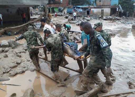 Handout picture released by the Colombian Army press office showing soldiers carrying a corpse following mudslides caused by heavy rains, in Mocoa, Putumayo department, on April 1, 2017.
Mudslides in southern Colombia -caused by the rise of the Mocoa River and three tributaries- have claimed at least 16 lives and injured some 65 people following recent torrential rains, the authorities said.   / AFP PHOTO / EJERCITO DE COLOMBIA / HO / RESTRICTED TO EDITORIAL USE - MANDATORY CREDIT AFP PHOTO /  EJERCITO DE COLOMBIA - NO MARKETING - NO ADVERTISING CAMPAIGNS - DISTRIBUTED AS A SERVICE TO CLIENTS

