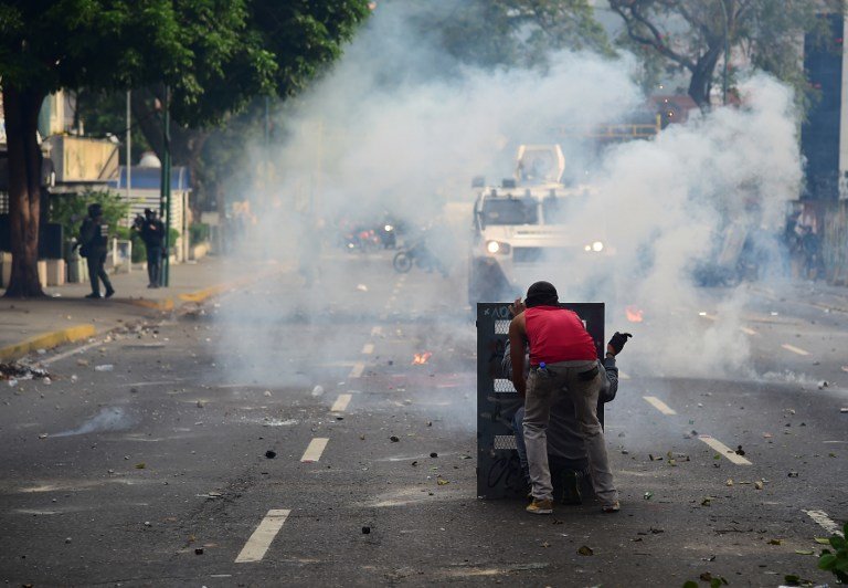 A demonstrator clashes with the police during a rally against Venezuelan President Nicolas Maduro, in Caracas on April 19, 2017.
Venezuelans took to the streets Wednesday for massive demonstrations for and against President Nicolas Maduro, whose push to tighten his grip on power has triggered deadly unrest that has escalated the country's political and economic crisis. / AFP PHOTO / RONALDO SCHEMIDT