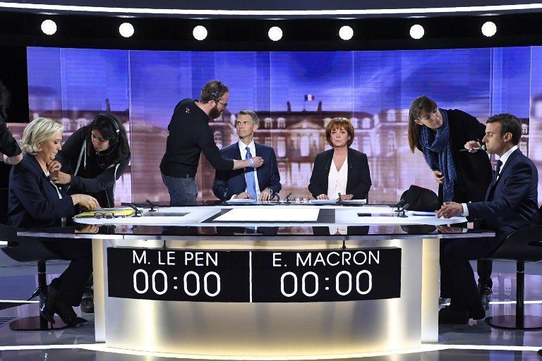(From L) French presidential election candidate for the far-right Front National (FN) party, Marine Le Pen, French journalist Christophe Jakubyszyn, French journalist Nathalie Saint-Cricq and French presidential election candidate for the En Marche ! movement, Emmanuel Macron get prepared by technicians prior to the start of a live brodcast face-to-face televised debate in television studios of French public national television channel France 2, and French private channel TF1 in La Plaine-Saint-Denis, north of Paris, on May 3, 2017 as part of the second round election campaign.Pro-EU centrist Emmanuel Macron and far-right leader Marine Le Pen face off in a final televised debate on May 3 that will showcase their starkly different visions of France's future ahead of this weekend's presidential election run-off.  / AFP PHOTO / POOL / Eric FEFERBERG
