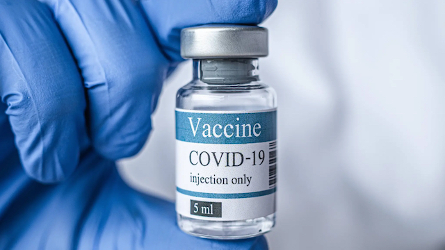 close-up-of-COVID-19-vaccine-vial-being-held-by-a-person-wearing-a-blue-PPE-glove-shutterstock_1678629760_Fotor-16x9-1 copia